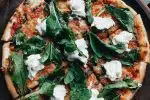 pizza with green leaves on top