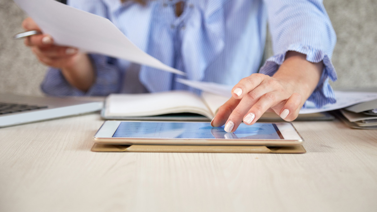 femme triant des papiers et apportant des informations sur une tablette